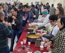 Participantes da oficina se servem em buffet com alimentos a base de pinhão e participantes
